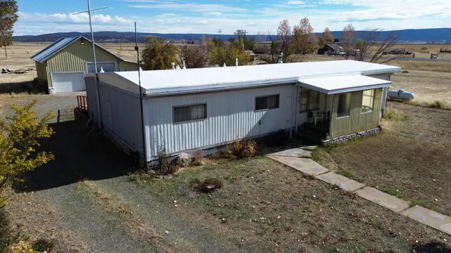 a view of a house with a yard and wooden fence