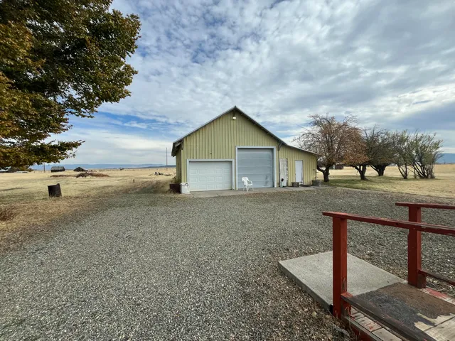 a view of backyard of house and car parked