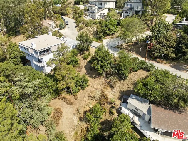 an aerial view of a house with a yard and trees