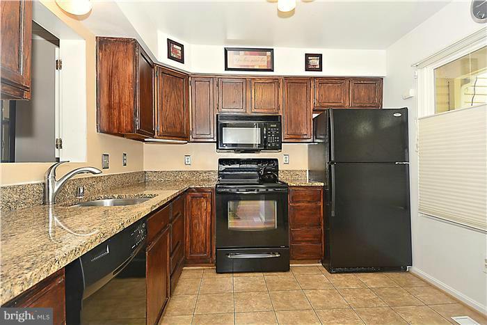 127 Kinsman View Circle Silver Spring, MD 20901 - Photo 4 of 21 a kitchen with granite countertop a refrigerator stove and microwave