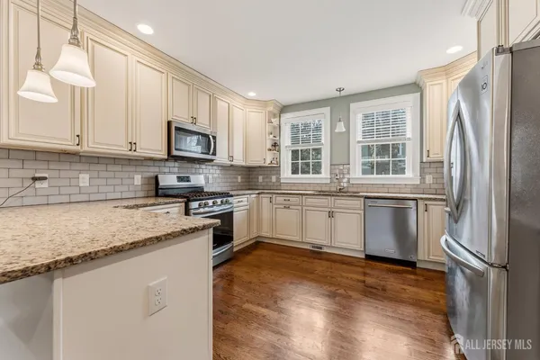 a kitchen with stainless steel appliances granite countertop a refrigerator sink and stove