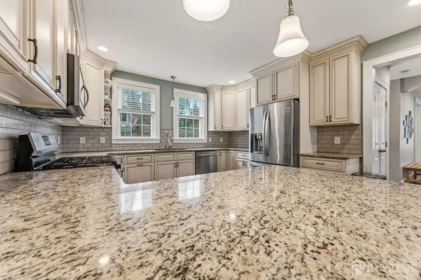 a large kitchen with kitchen island a sink stainless steel appliances and a counter space