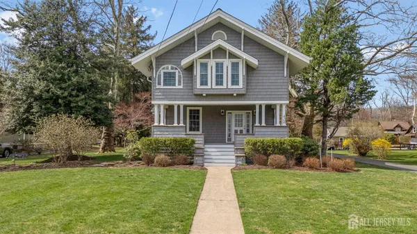 a front view of a house with a yard and trees