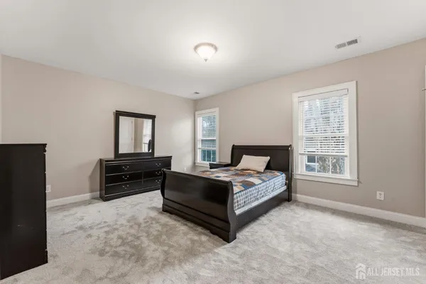 a spacious bedroom with a bed and a window