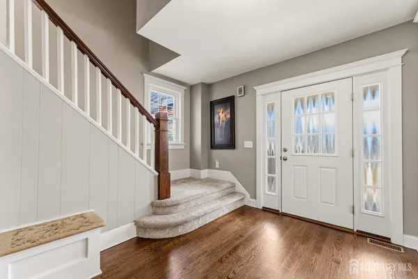 a view of entryway and hall with wooden floor
