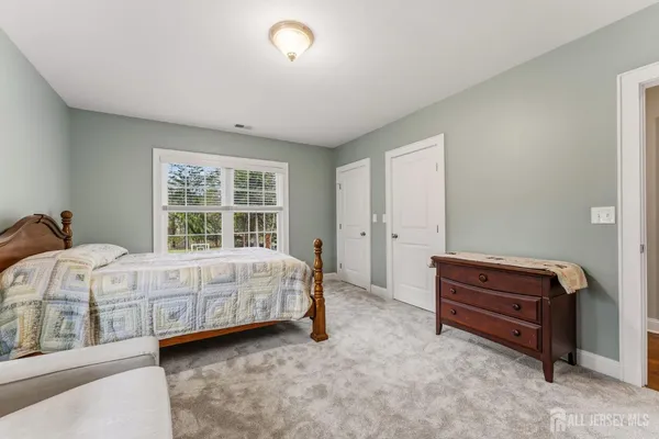 a front view of a house with a garden and trees