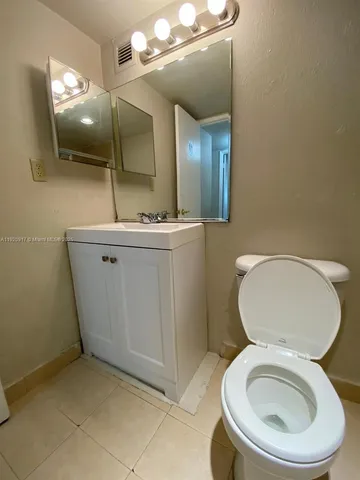 a bathroom with a toilet a sink and mirror