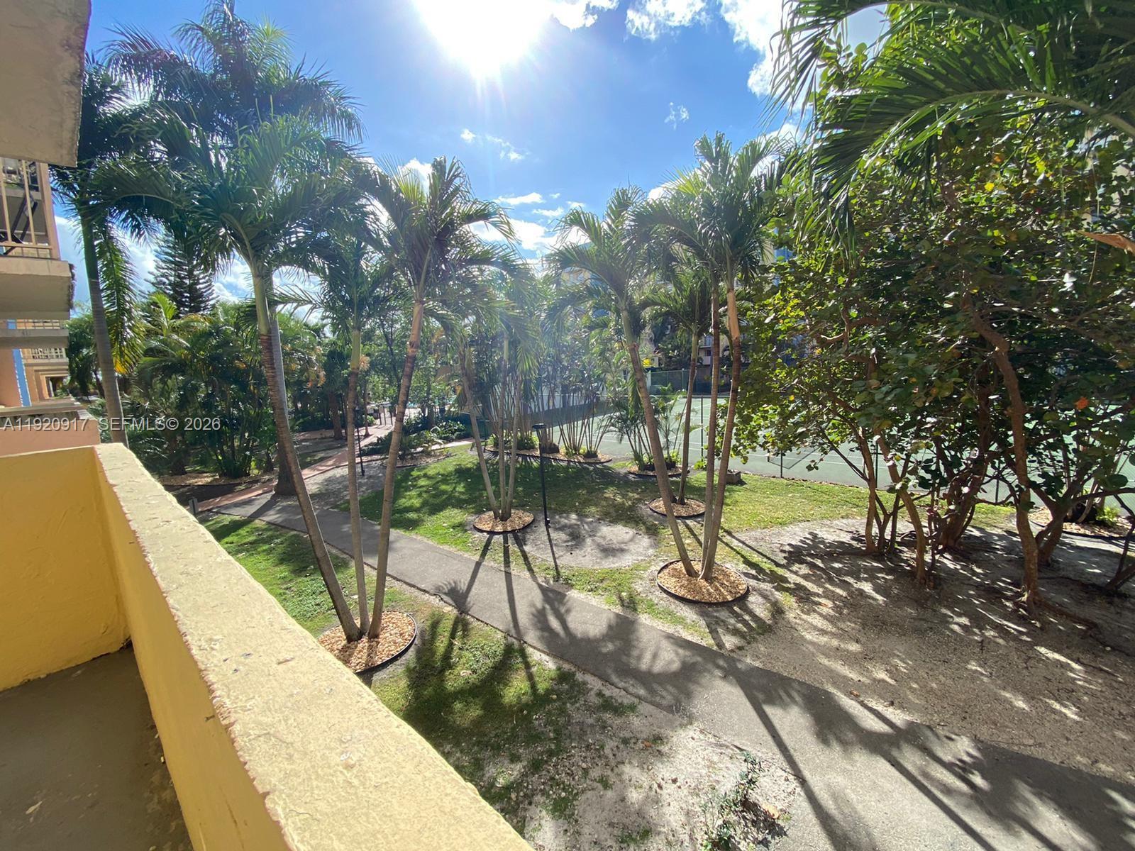 4550 Northwest 9th Street, Unit 217E Miami, FL 33126 - Photo 4 of 14 a view of swimming pool with a bench and trees