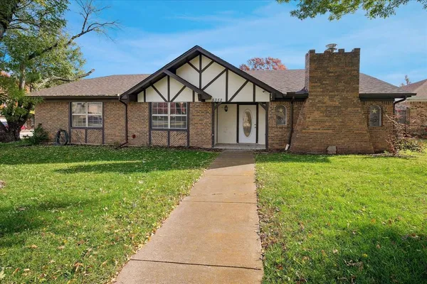 a view of a big house with a big yard and large trees