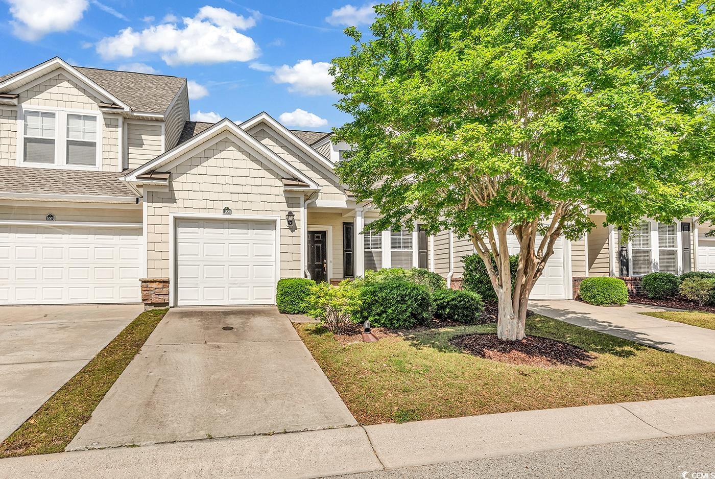 Multi unit property featuring driveway, a shingled roof, and a garage