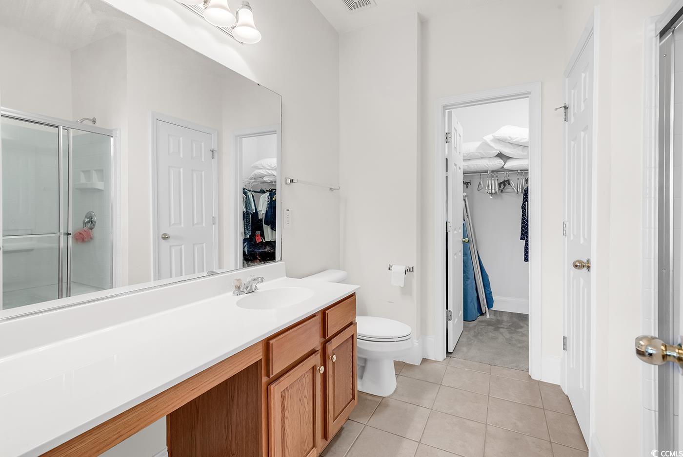 101 Culpepper Way, Unit 1006 Myrtle Beach, SC 29579 - Photo 14 of 40 Bathroom with a shower stall, tile patterned flooring, toilet, vanity, and a spacious closet