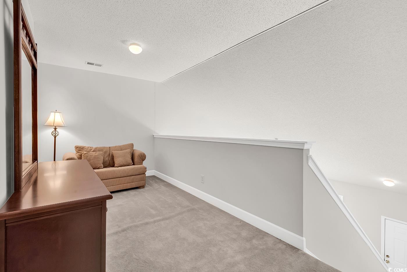 101 Culpepper Way, Unit 1006 Myrtle Beach, SC 29579 - Photo 18 of 40 Loft Living area featuring light colored carpet, a textured ceiling, vaulted ceiling, and baseboards