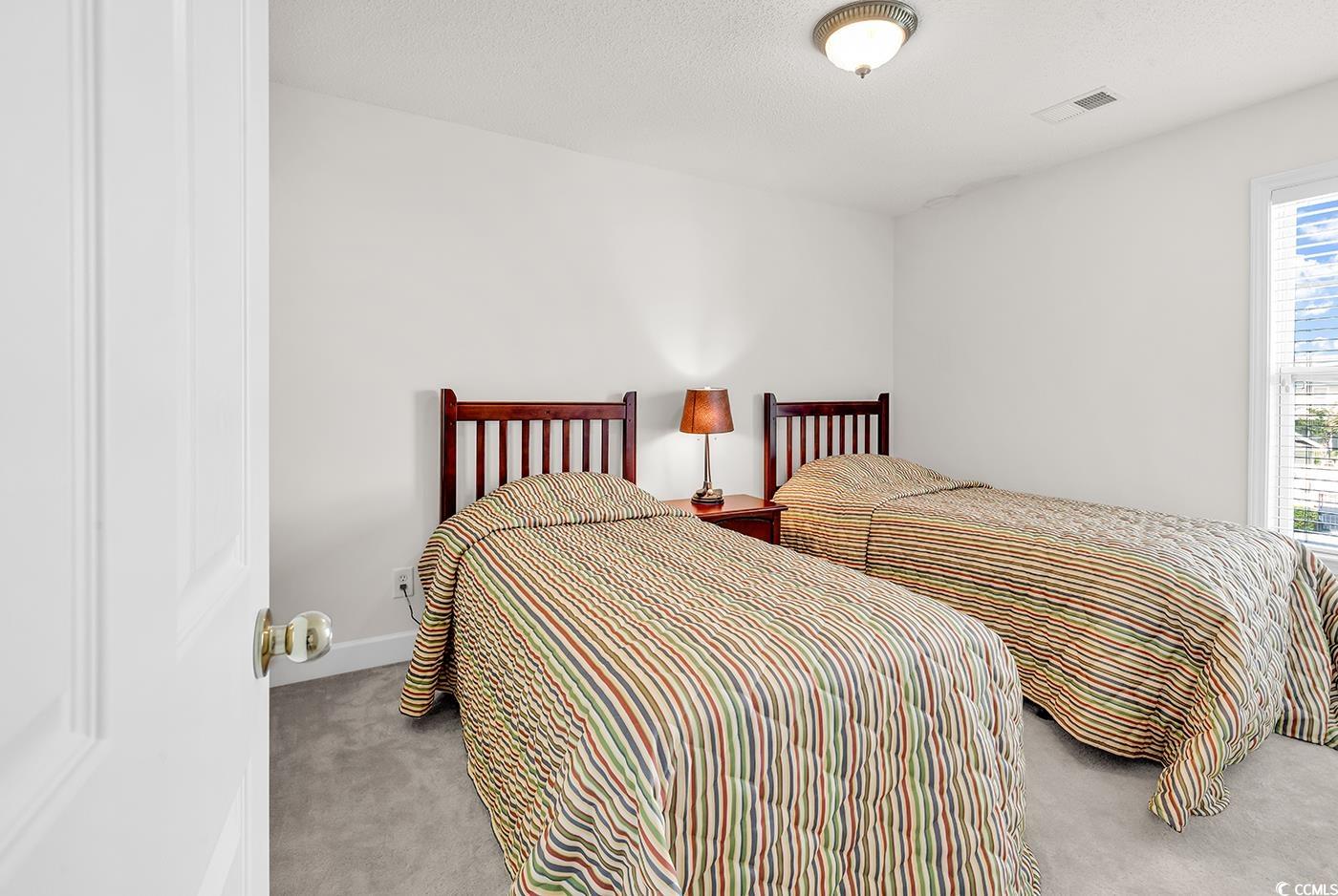 101 Culpepper Way, Unit 1006 Myrtle Beach, SC 29579 - Photo 19 of 40 Bedroom with light colored carpet and multiple windows