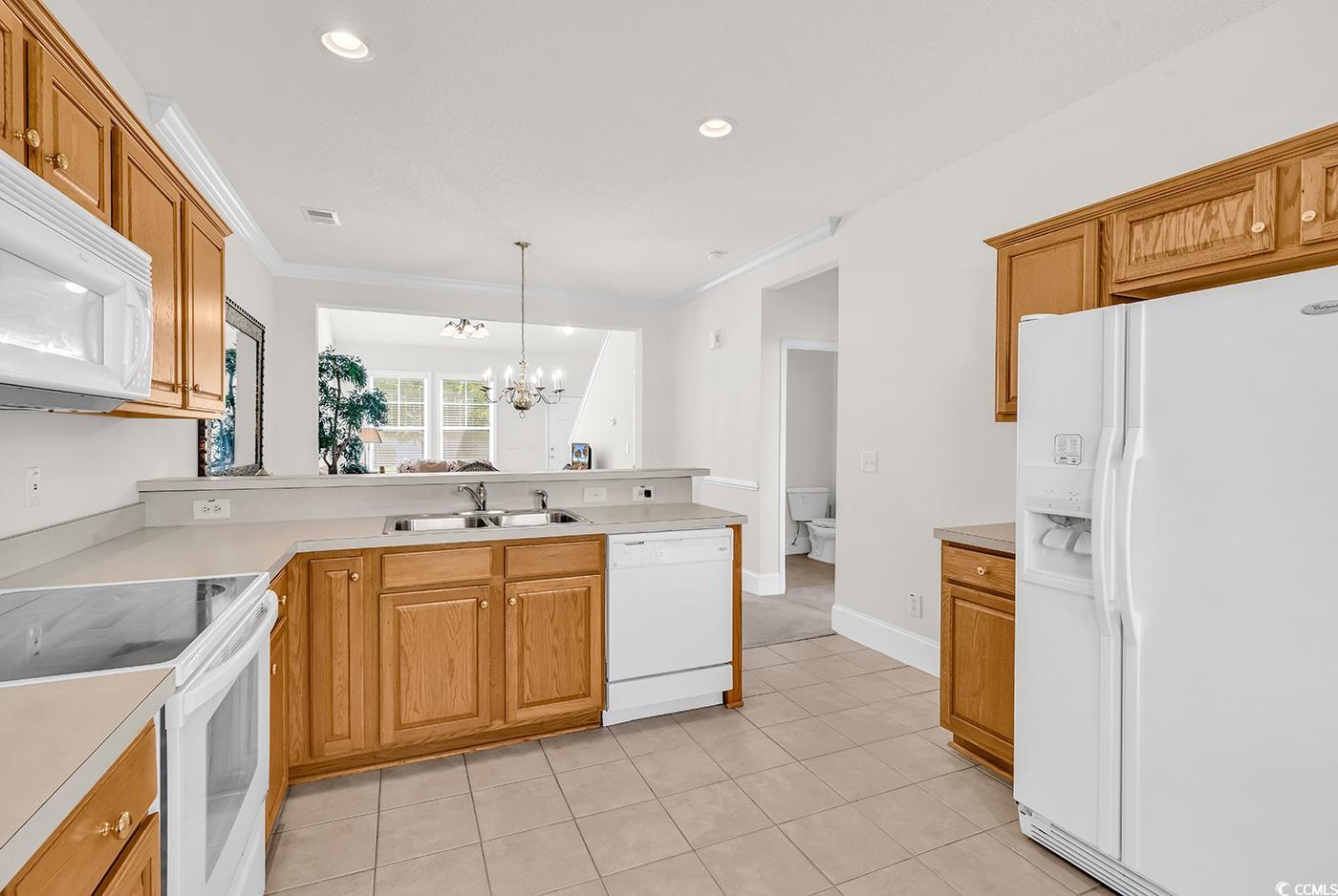 101 Culpepper Way, Unit 1006 Myrtle Beach, SC 29579 - Photo 10 of 40 Kitchen featuring white appliances, a sink, a chandelier, a peninsula, and light tile patterned flooring