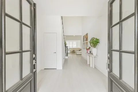 a kitchen with stainless steel appliances granite countertop a stove a sink a refrigerator and white cabinets with wooden floor