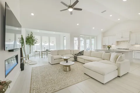 a kitchen with white cabinets and a stove with wooden floor
