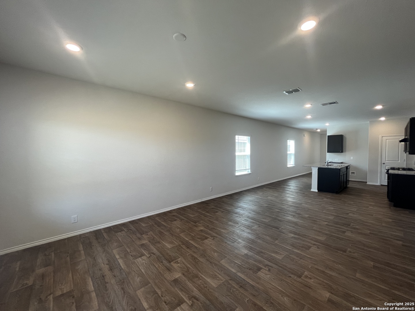 141 Middle Grn Loop Floresville, TX 78114 - Photo 7 of 29 an empty room with wooden floor and windows