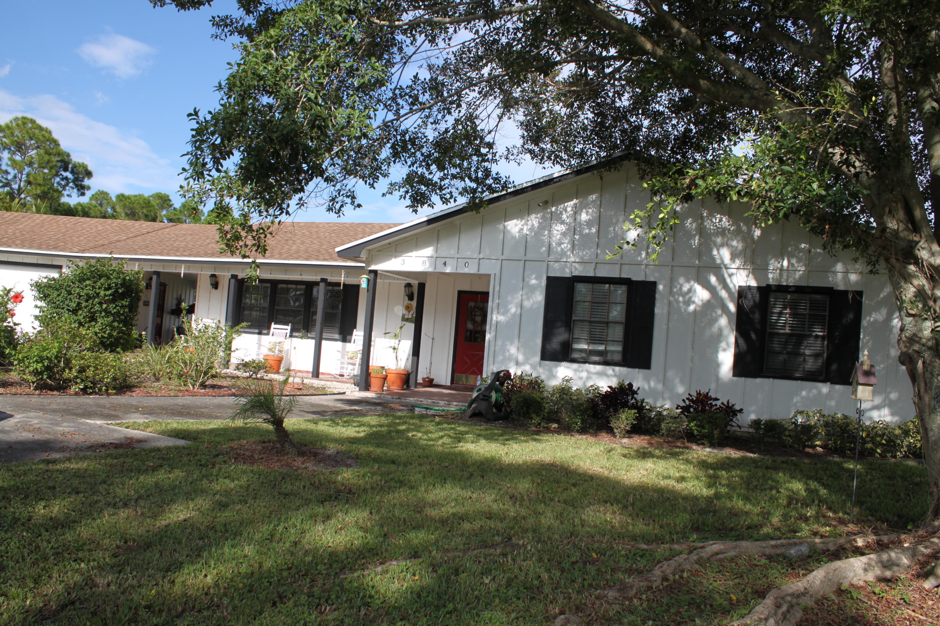 3840 Dellwood Road Loxahatchee, FL 33470 - Photo 1 of 60 a front view of a house with porch and garden