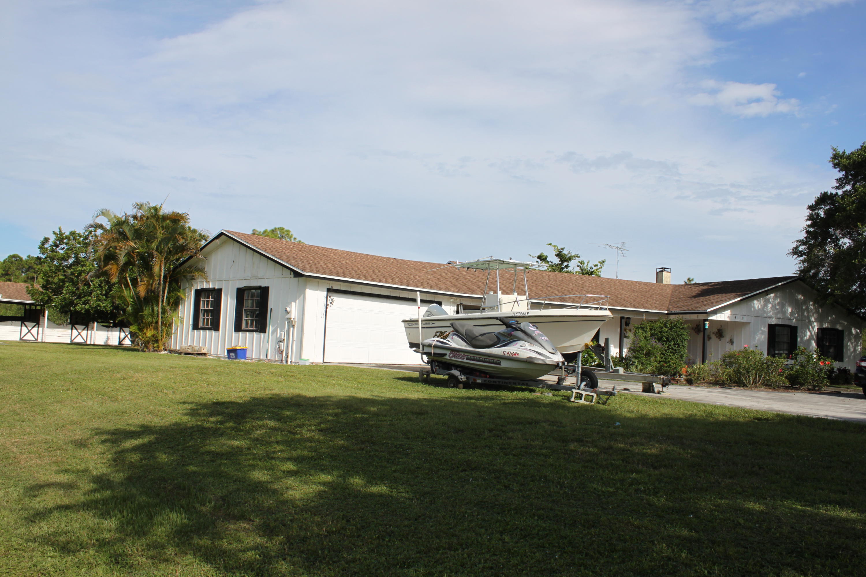 3840 Dellwood Road Loxahatchee, FL 33470 - Photo 14 of 60 a couple of lawn chairs sitting in front of a house with a yard