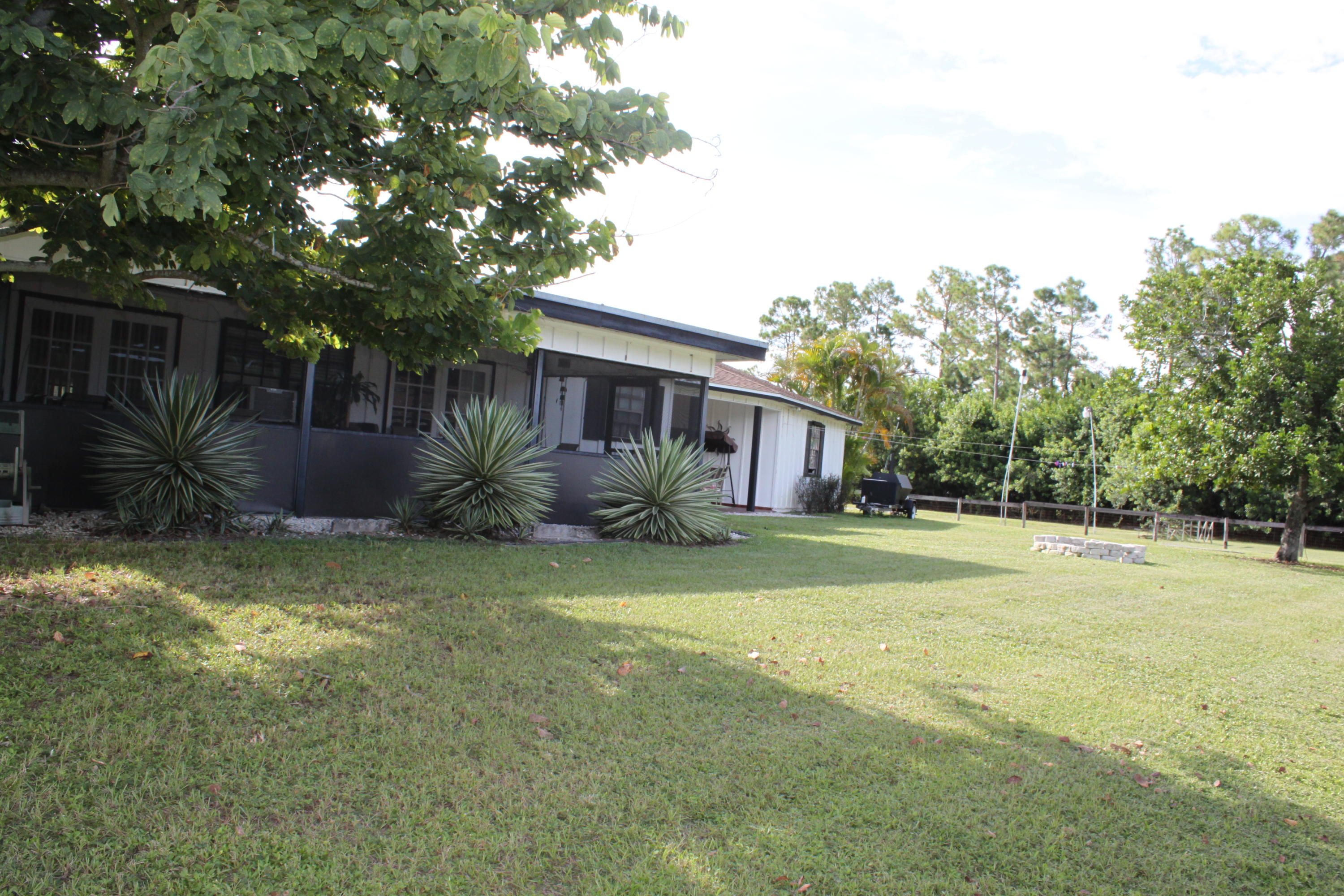 3840 Dellwood Road Loxahatchee, FL 33470 - Photo 42 of 60 a view of a house with a yard and a large tree
