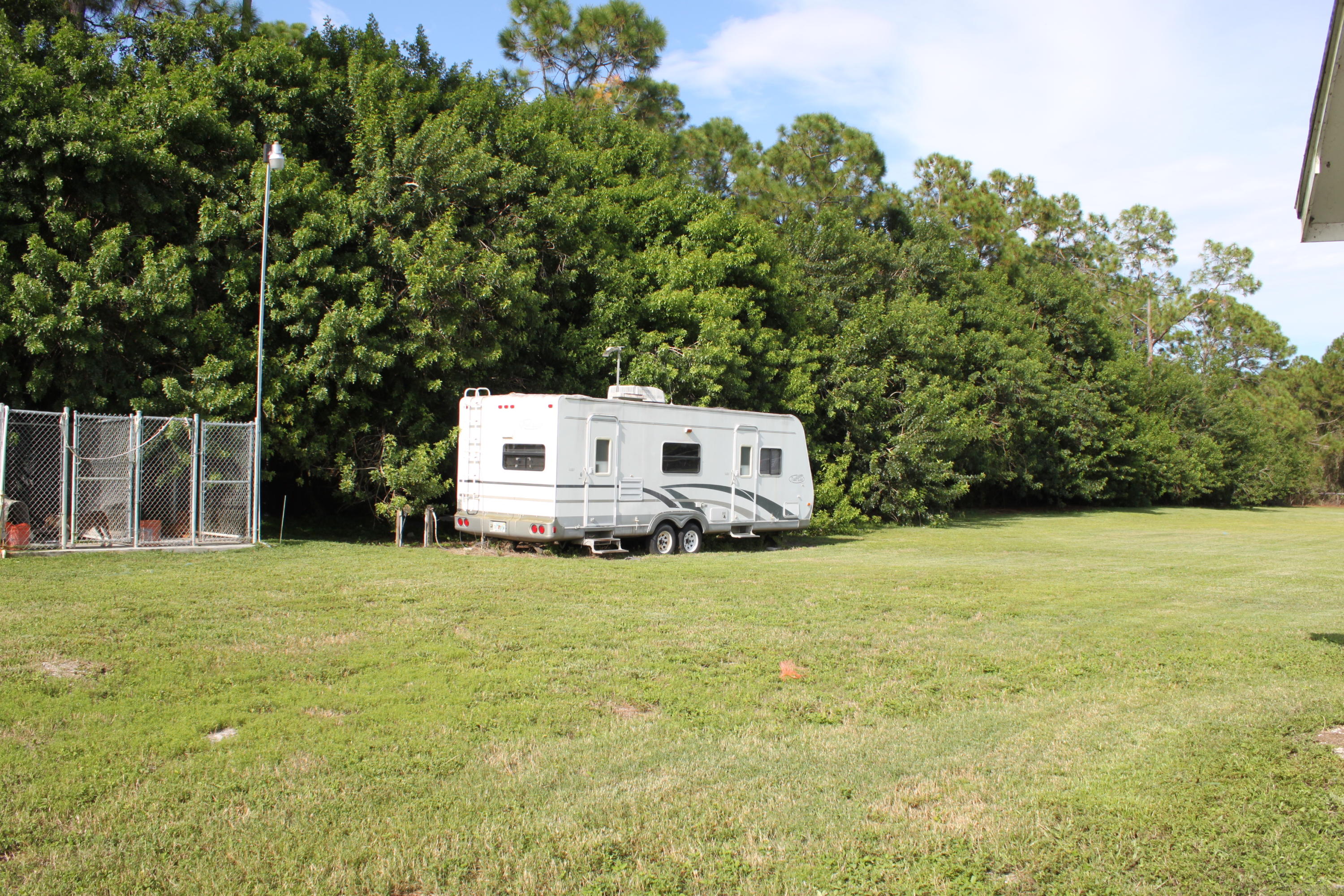 3840 Dellwood Road Loxahatchee, FL 33470 - Photo 45 of 60 a house with trees in the background