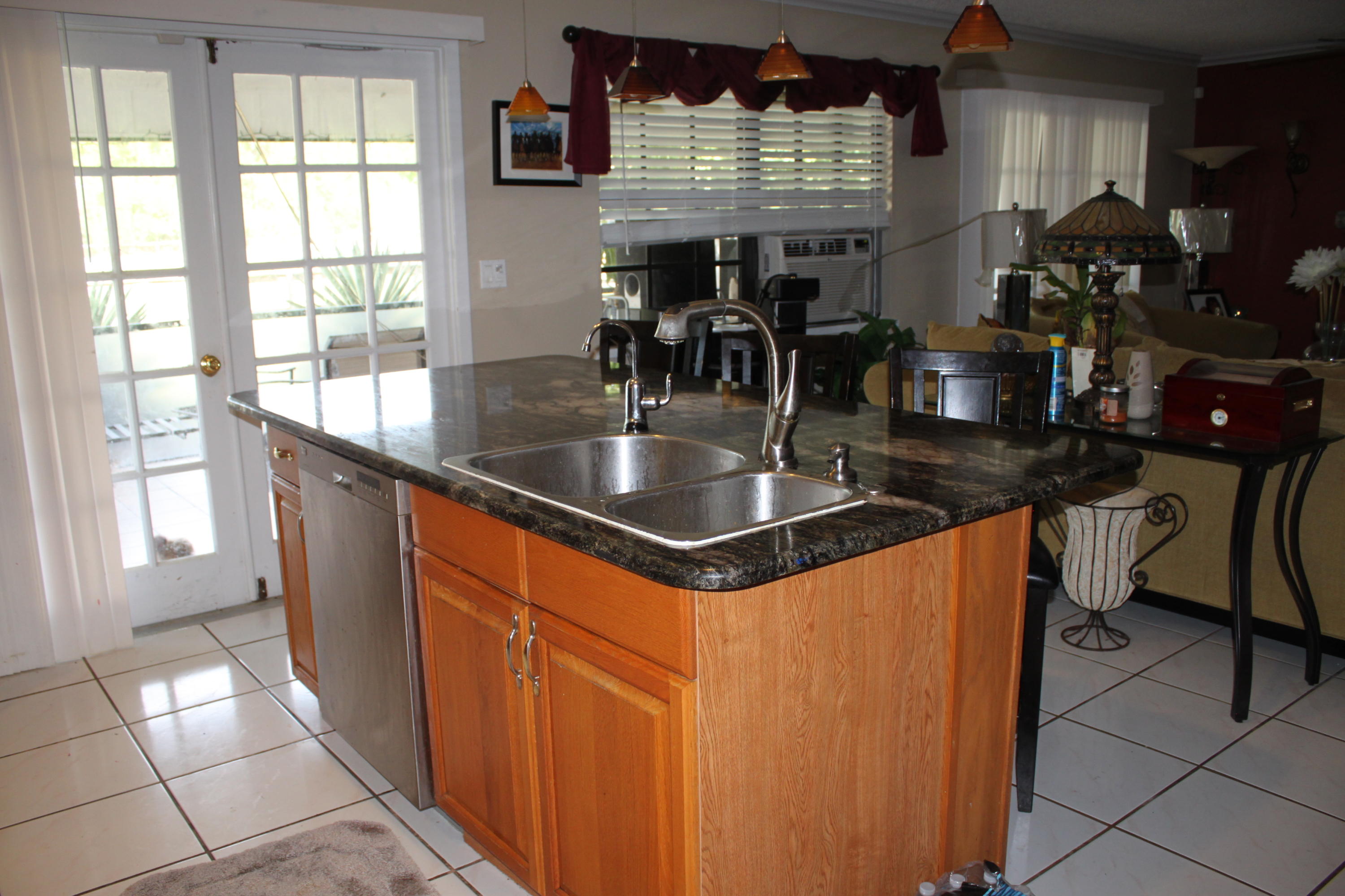 3840 Dellwood Road Loxahatchee, FL 33470 - Photo 57 of 60 a kitchen with granite countertop a sink and a window