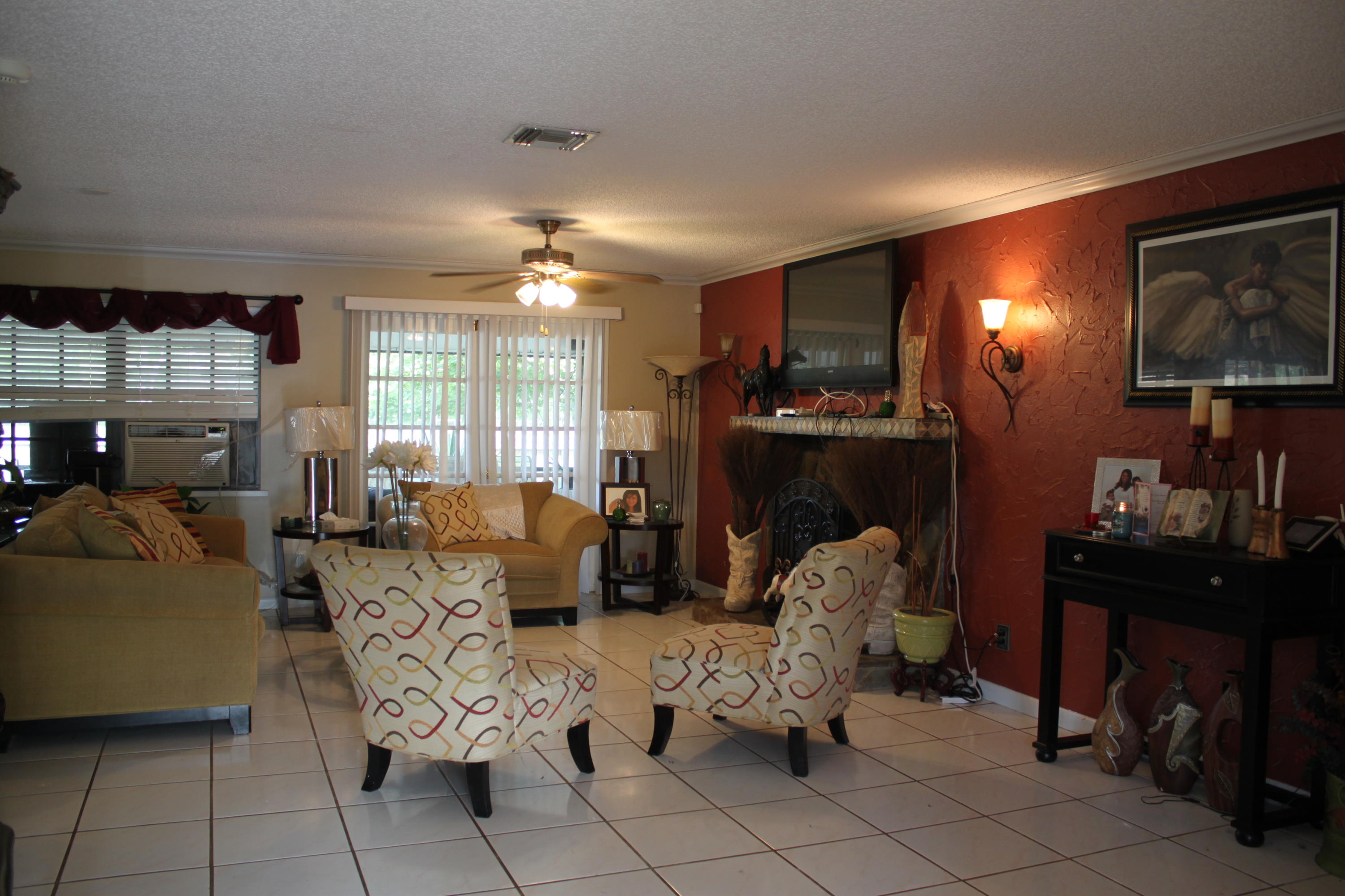 3840 Dellwood Road Loxahatchee, FL 33470 - Photo 60 of 60 a living room with furniture a lamp and a fireplace