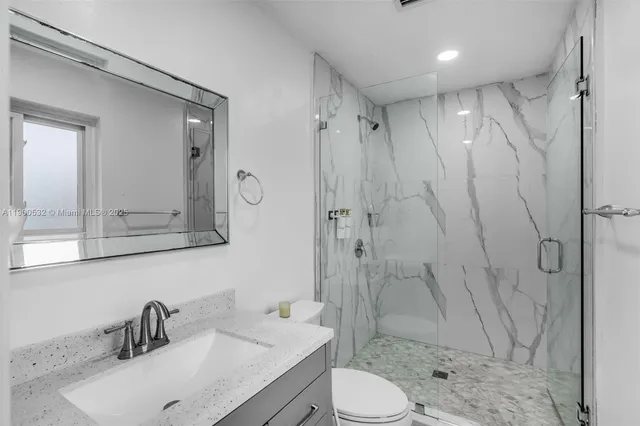 a bathroom with a sink toilet a mirror and shower
