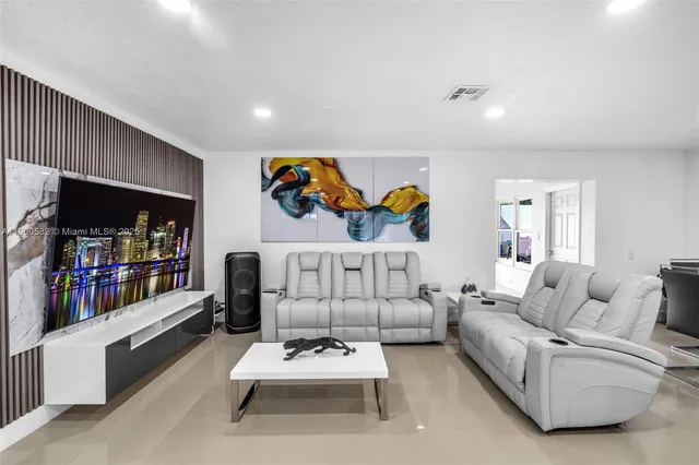 a living room with furniture a rug and white walls