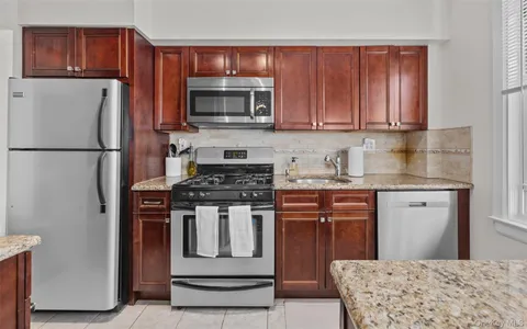 a kitchen with stainless steel appliances granite countertop a refrigerator stove a sink dishwasher and microwave oven