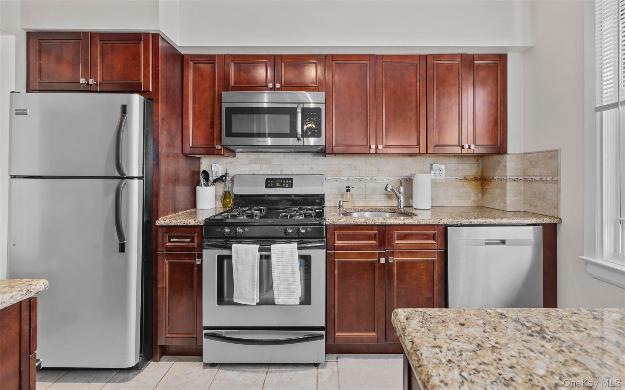 2 Edwards Street, Unit 3D Roslyn Heights, NY 11577 - Photo 11 of 20 a kitchen with stainless steel appliances granite countertop a refrigerator stove a sink dishwasher and microwave oven