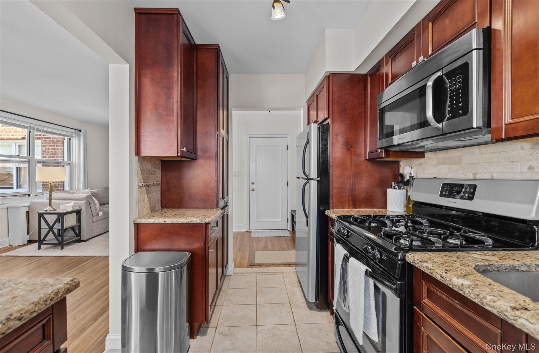 2 Edwards Street, Unit 3D Roslyn Heights, NY 11577 - Photo 13 of 20 a kitchen with stainless steel appliances granite countertop a stove a sink and a microwave