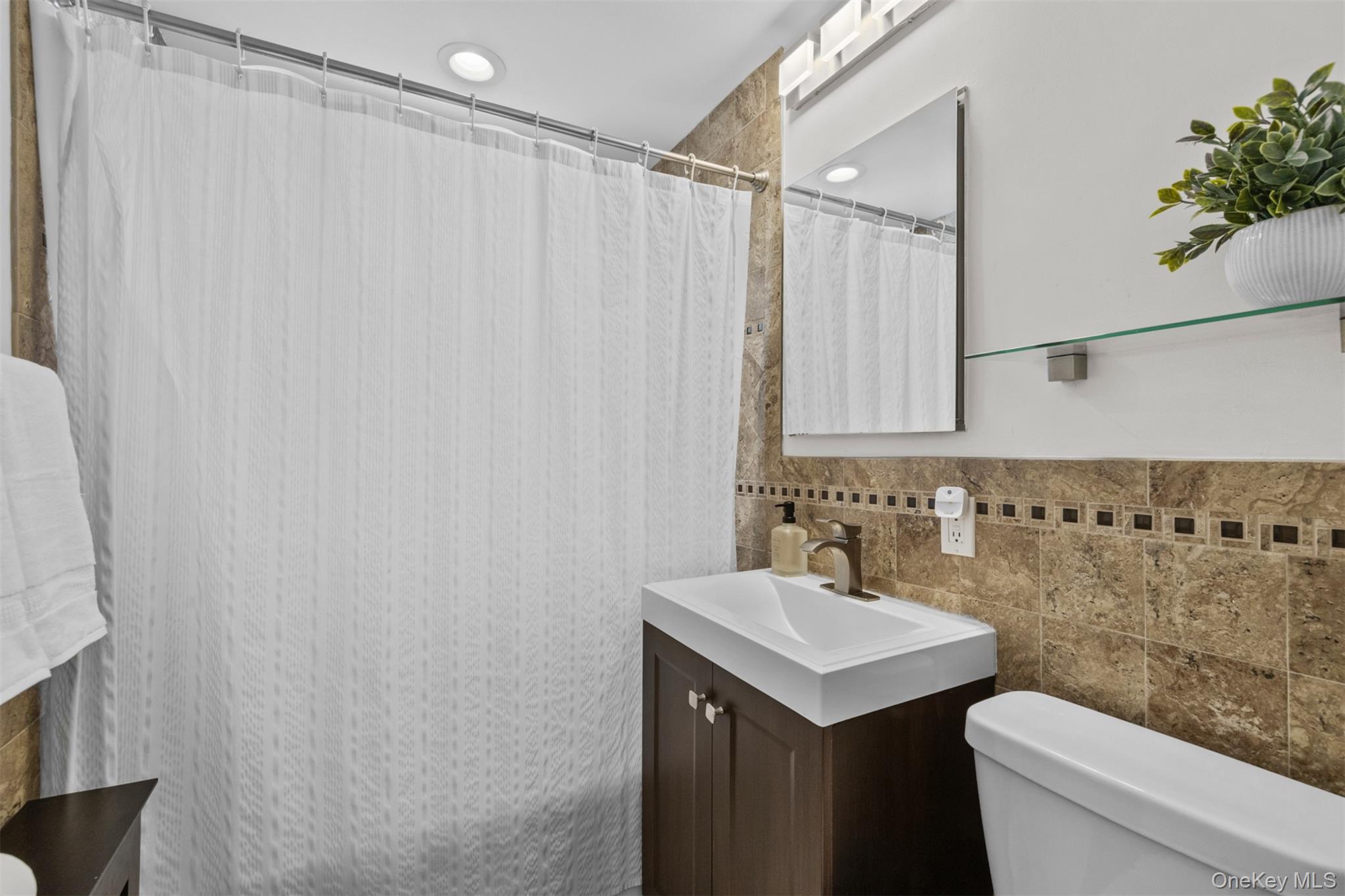 2 Edwards Street, Unit 3D Roslyn Heights, NY 11577 - Photo 14 of 20 a bathroom with a sink a toilet and shower