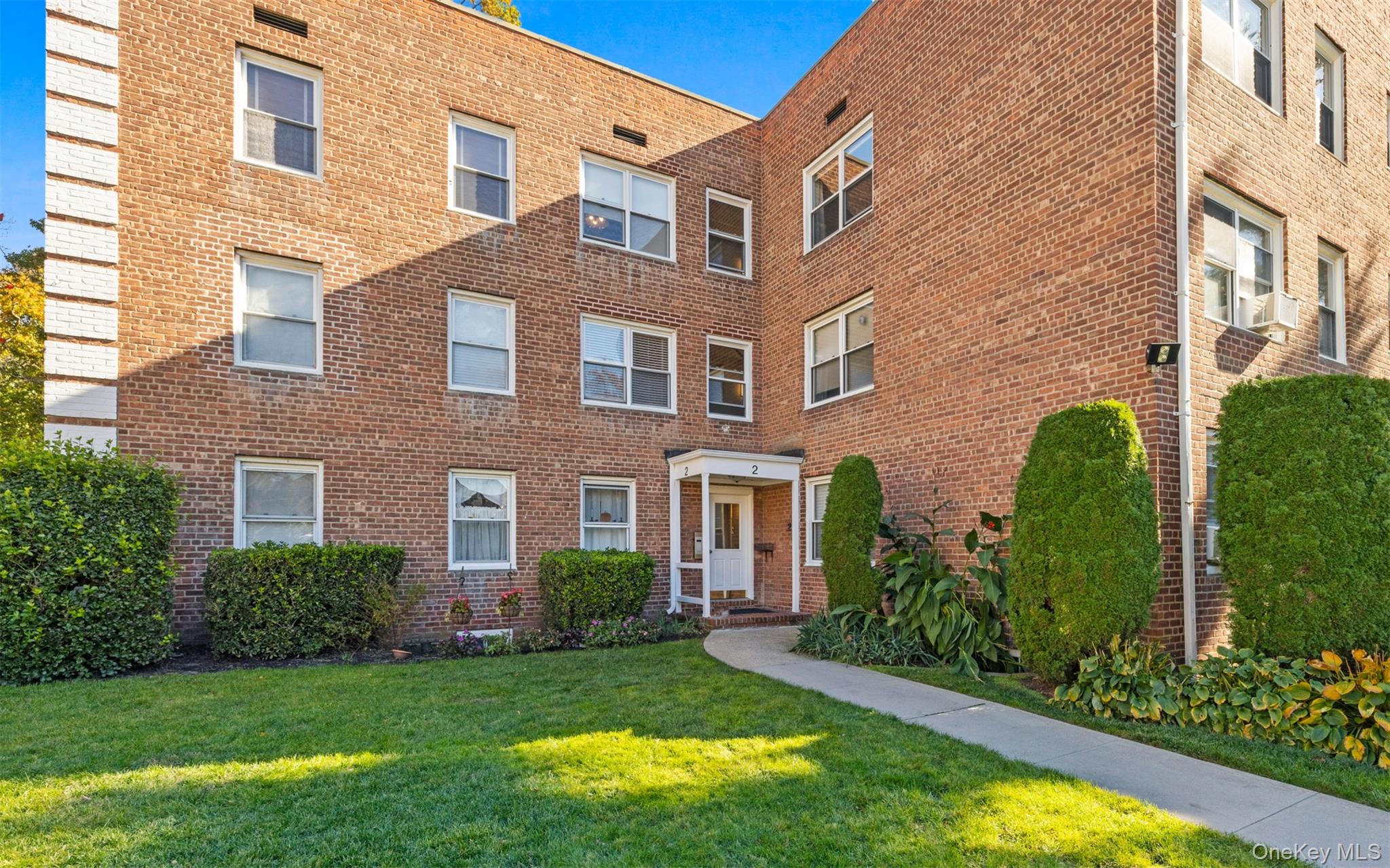 2 Edwards Street, Unit 3D Roslyn Heights, NY 11577 - Photo 2 of 20 a view of a brick building next to a yard