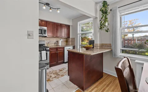 a kitchen with stainless steel appliances granite countertop a refrigerator a stove a sink dishwasher and microwave with wooden floor