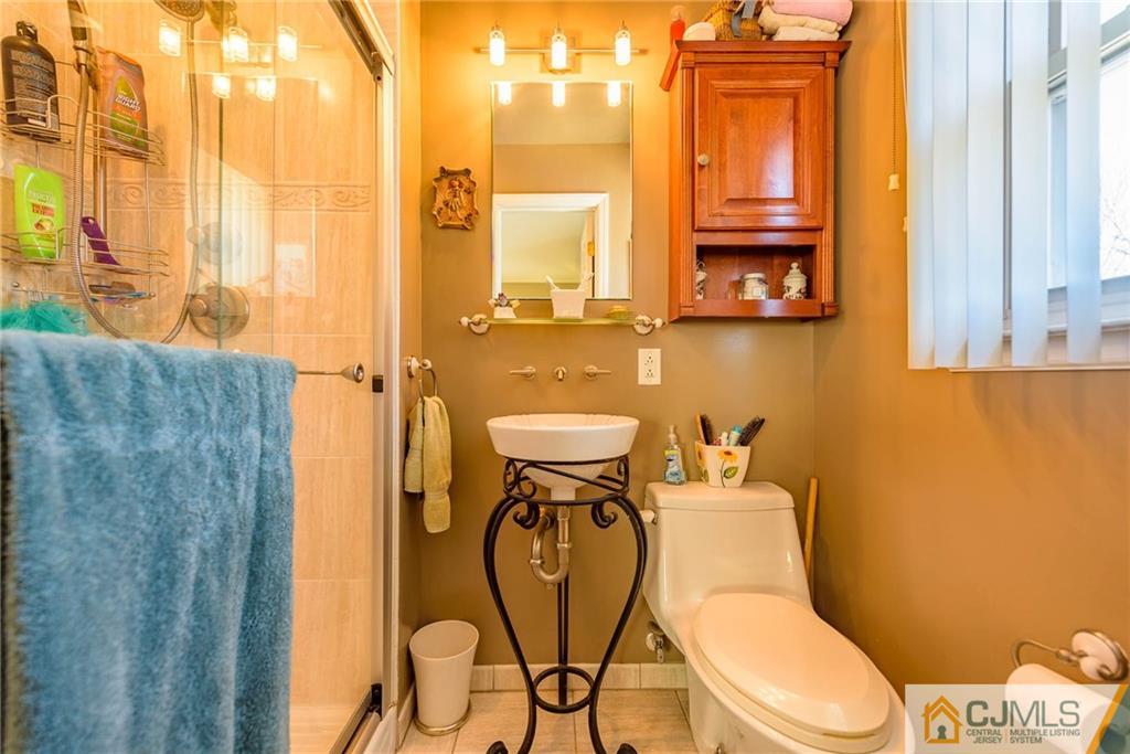 141 Devon Road Colonia, NJ 07067 - Photo 15 of 25 a bathroom with a toilet mirror and vanity
