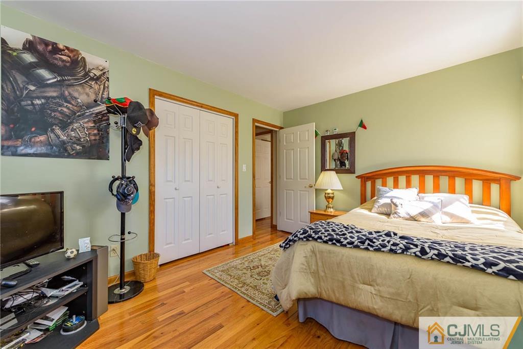 141 Devon Road Colonia, NJ 07067 - Photo 17 of 25 a bedroom with a bed and a flat tv screen on the dresser