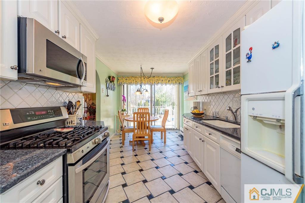 141 Devon Road Colonia, NJ 07067 - Photo 10 of 25 a kitchen with stainless steel appliances a stove a sink and a microwave