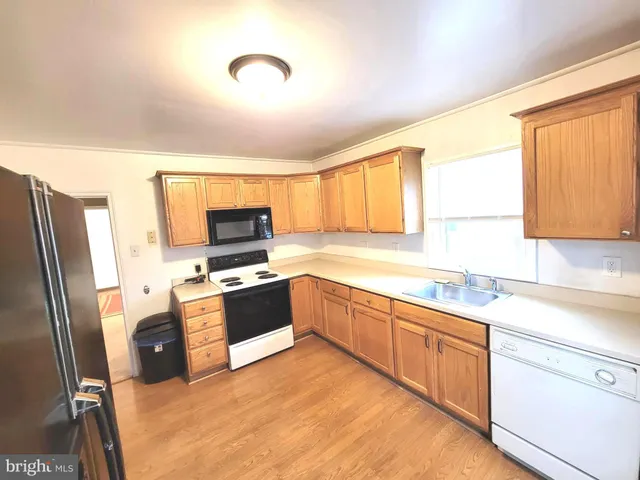 a kitchen with stainless steel appliances granite countertop a refrigerator sink and stove