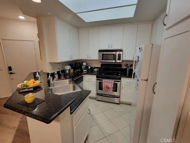 a kitchen with stainless steel appliances granite countertop a refrigerator a stove a sink dishwasher and a refrigerator