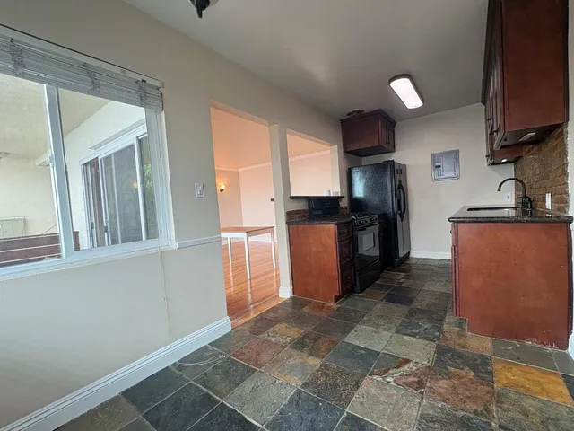 a kitchen with stainless steel appliances granite countertop a refrigerator and a sink