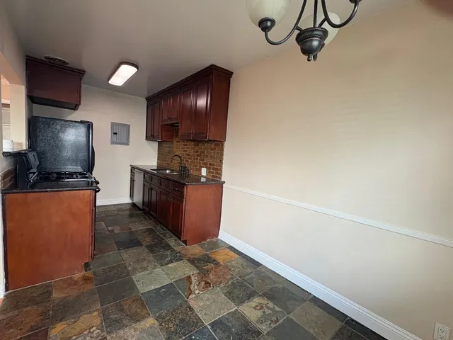 a kitchen with granite countertop a refrigerator and a stove top oven