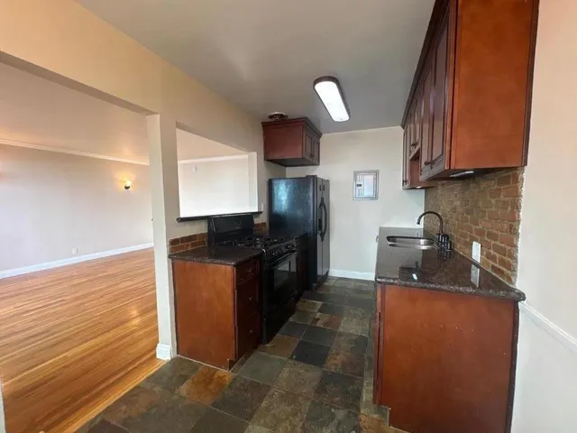 a kitchen with granite countertop a sink and a stove top oven