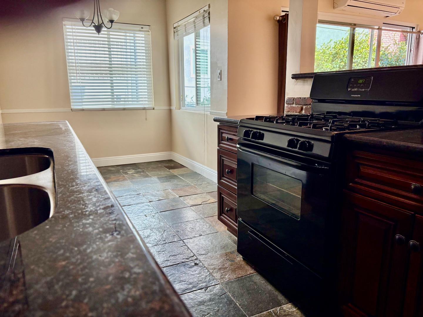 11719 Mayfield Avenue, Unit 1 Los Angeles, CA 90049 - Photo 17 of 28 a kitchen with a stove a microwave and a window