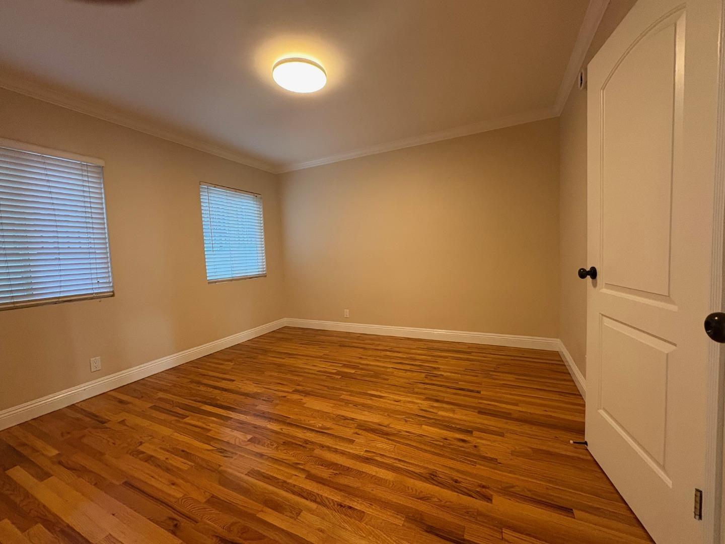 11719 Mayfield Avenue, Unit 1 Los Angeles, CA 90049 - Photo 24 of 28 a view of an empty room with wooden floor and a window