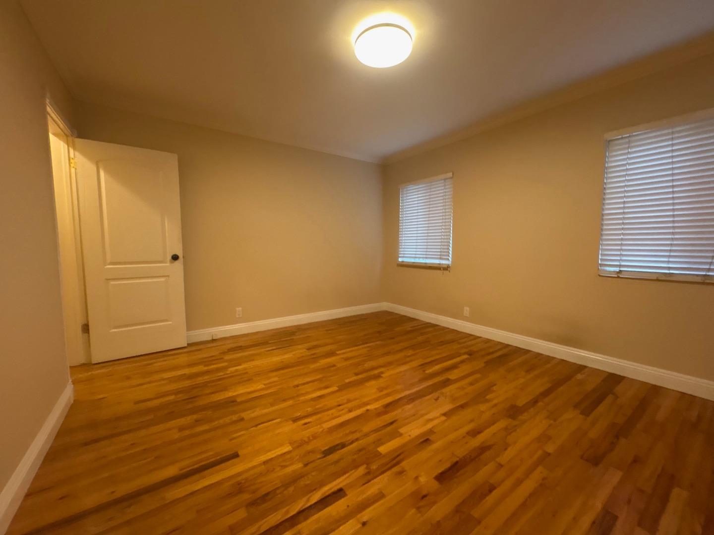 11719 Mayfield Avenue, Unit 1 Los Angeles, CA 90049 - Photo 28 of 28 an empty room with wooden floor and windows
