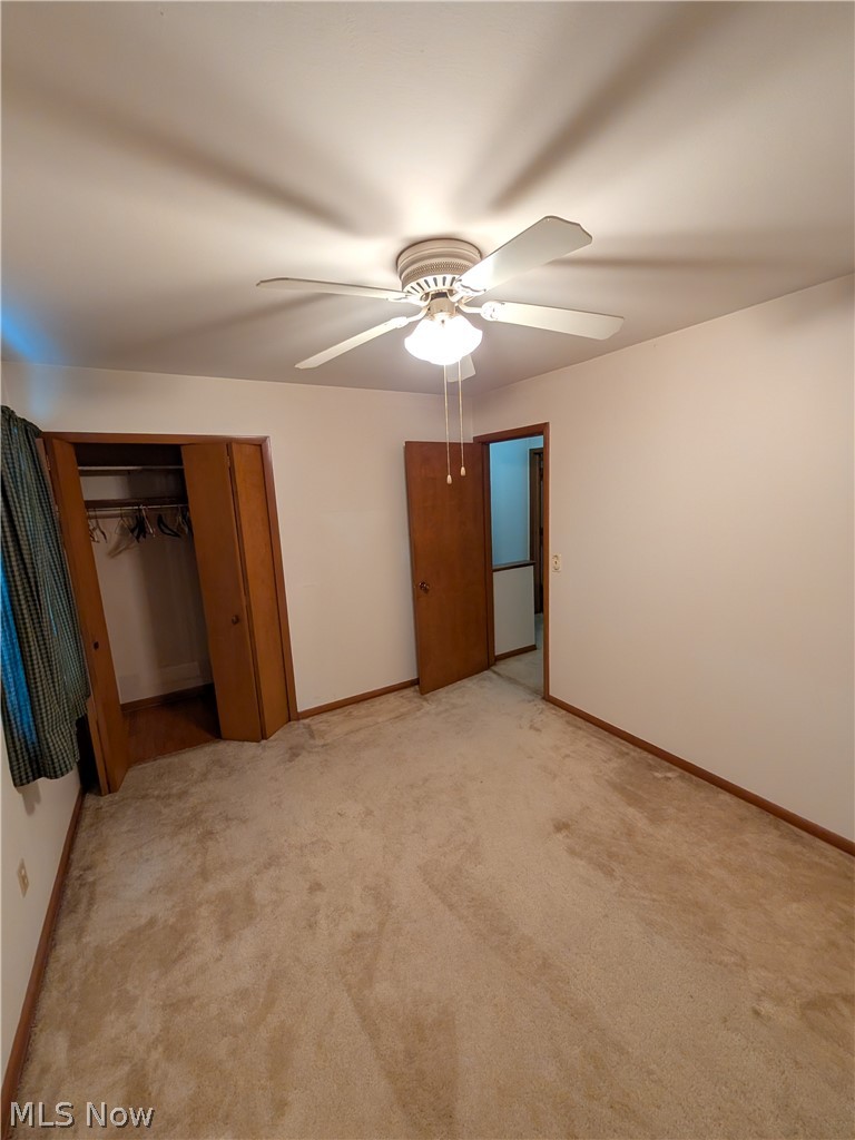 1161 Gulf Road Elyria, OH 44035 - Photo 25 of 34 Carpeted room featuring a ceiling fan with integrated lighting, wood-finish bi-fold closet doors, and a wood-finish interior door
