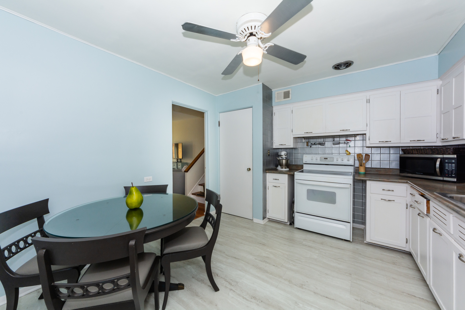 2232 South 3rd Avenue Riverside, IL 60546 - Photo 8 of 26 a kitchen with stainless steel appliances a dining table chairs and white cabinets