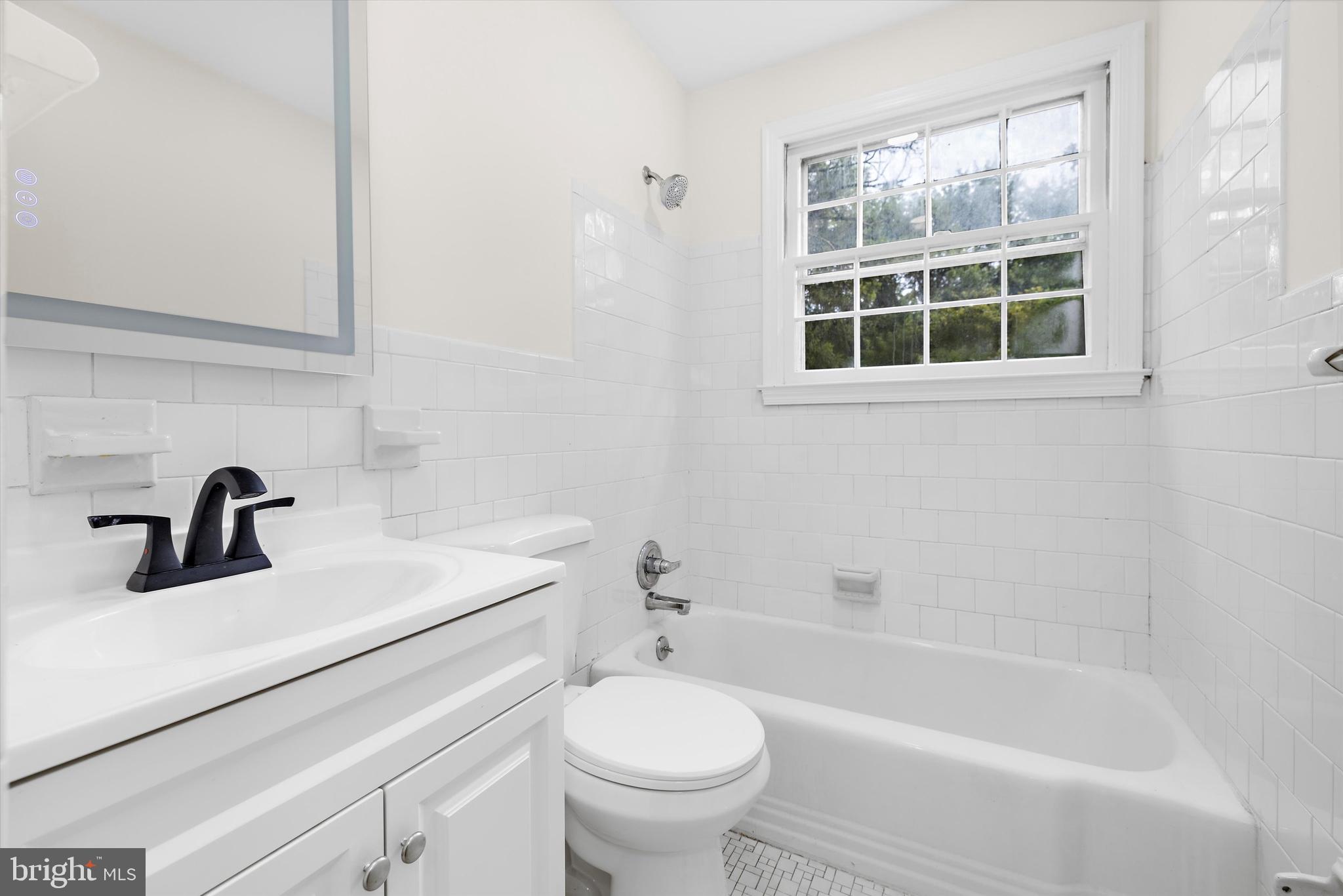 2301 Pickwick Road Baltimore, MD 21207 - Photo 16 of 50 a bathroom with a sink a toilet and a bathtub