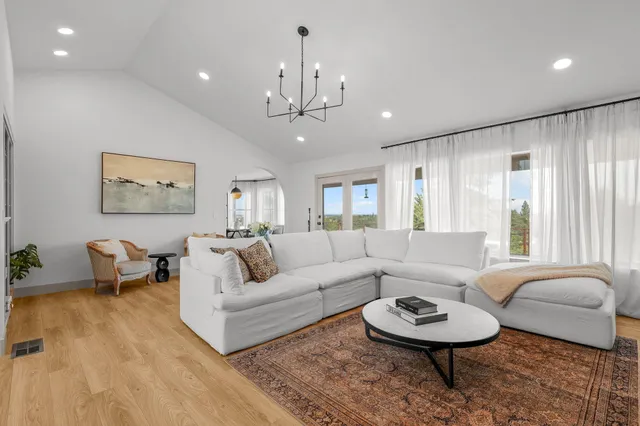 a living room with furniture a fireplace and a chandelier